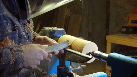 photo de realisation de pied de lampe en bois tourné dans l'atelier de tournage sur bois. gouge a dégrossir, tour à bois. pied de lampe en bois tourné sur mesure. artisanat d'art, artisanal, fait-main.